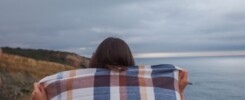 Femme qui lâche son écharpe au bord d'une falaise
